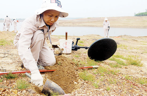 Chị Hoàng Thị Hải Lý đào tìm bom bi sau khi máy dò báo tín hiệu