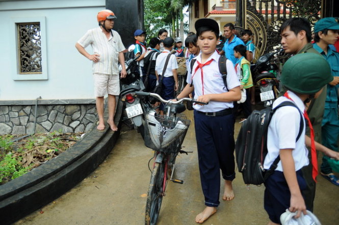 Cởi giày, đi chân đất để dễ băng lũ - Ảnh: A Lộc