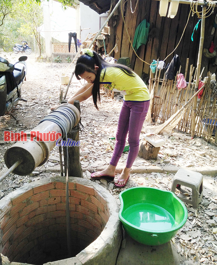 Không có điện để dùng máy bơm nên em Lương Thị Lan Điệp hằng ngày phải phụ cha mẹ quay nước từ giếng lên