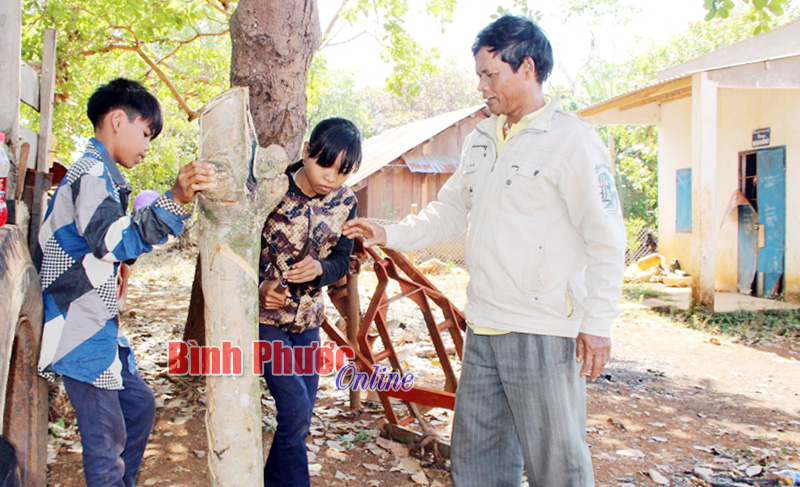 Ông Điểu Mách hướng dẫn lớp trẻ trong thôn kỹ thuật cạo mủ cao su