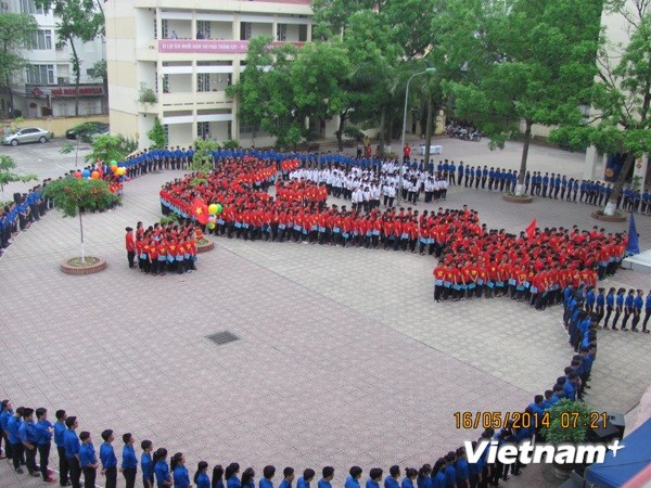 Trong tiếng nhạc bài Dòng máu lạc hồng, học sinh xếp thành hình Tổ quốc giữa một trái tim lớn của màu xanh tình nguyện