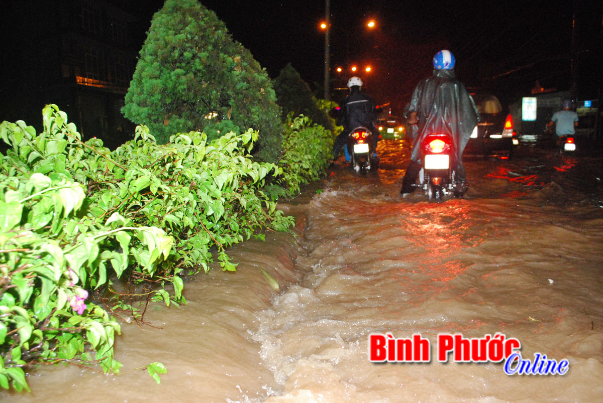 Nước tràn qua giải phân cách gây “khó” cho các phương tiện