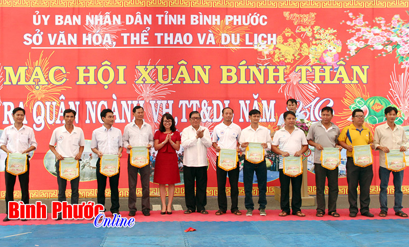 Phó ban Tuyên giáo Tỉnh ủy Nguyễn Thị Minh Nhâm và Giám đốc Sở Văn hóa - Thể thao và Du lịch Nguyễn Tuấn trao cờ lưu niệm cho các đơn vị tham gia hội xuân