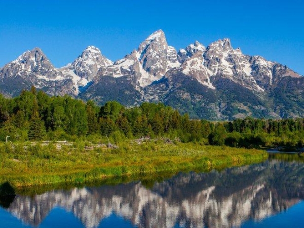 Công viên quốc gia Grand Teton ở Wyoming, khách sẽ có cơ hội chiêm ngưỡng cảnh quan phong phú của nhiều hồ, địa hình núi cao soi bóng. Bên cạnh phong cảnh, công viên cũng là nơi ở của lượng lớn cá hồi. Nhưng việc trái đất ấm lên khiến số lượng loài vật này bị giảm xuống đáng kể. 