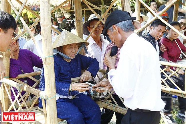 Người già thích thú với trò chơi bài chòi khi đi chợ quê Thanh Toàn. Ảnh: Thanh Giang/Báo ảnh Việt Nam