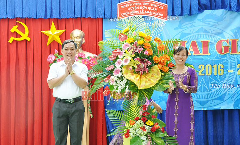 Đồng chí Lê Hoàng Lâm, Tỉnh ủy viên, Bí thư Huyện ủy Hớn Quản tặng hoa chúc mừng thầy, trò Trường Tiểu học Tân Hiệp nhân năm học mới