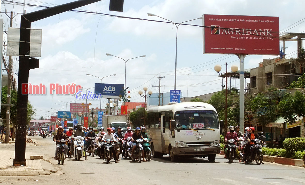 Không chấp hành tín hiệu đèn đỏ hay đèn vàng cũng bị phạt với mức như nhau là không phù hợp với Luật Giao thông đường bộ. Trong  ảnh, người tham gia giao thông chấp hành hiệu lệnh của đèn tín hiệu giao thông ở nội ô thị xã Đồng Xoài - Ảnh: S.H