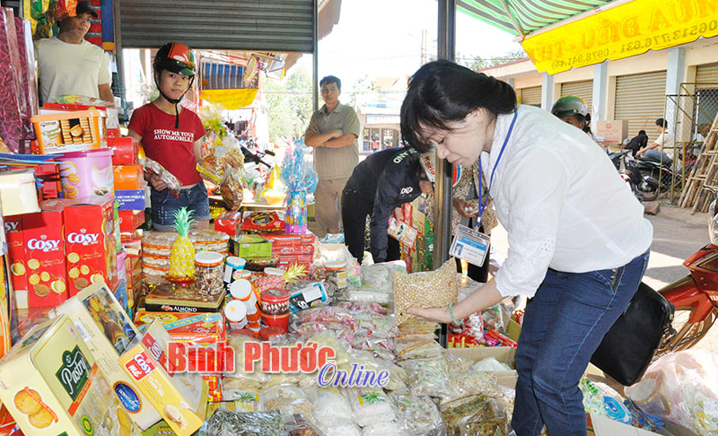 Lực lượng chức năng kiểm tra chất lượng hàng hóa tại chợ Bù Nho, huyện Phú Riềng - Ảnh: Tuyết Ly