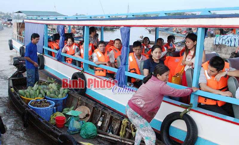 Tiểu thương cặp ghe vào thuyền du lịch để bán trái cây cho du khách.