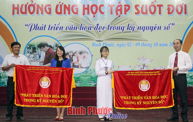 Phó chủ tịch UBND tỉnh Nguyễn Tiến Dũng và Phó ban Tuyên giáo Tỉnh ủy Nguyễn Thị Minh Nhâm trao thông điệp cho đại diện Trung tâm học tập cộng đồng phường Tân Xuân, thị xã Đồng Xoài và đại diện học sinh