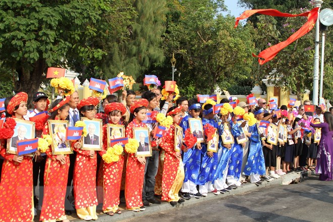  Ảnh Tổng Bí thư, Chủ tịch nước Nguyễn Phú Trọng và Quốc vương Campuchia Norodom Sihamoni được long trọng đặt tại trung tâm Thủ đô Phnom Penh. (Ảnh: Minh Hưng/TTXVN)   Các em học sinh Việt Nam tại Campuchia chào mừng Tổng Bí thư, Chủ tịch nước Nguyễn Phú Trọng phía ngoài Hoàng Cung. (Ảnh: Minh Hưng/TTXVN)