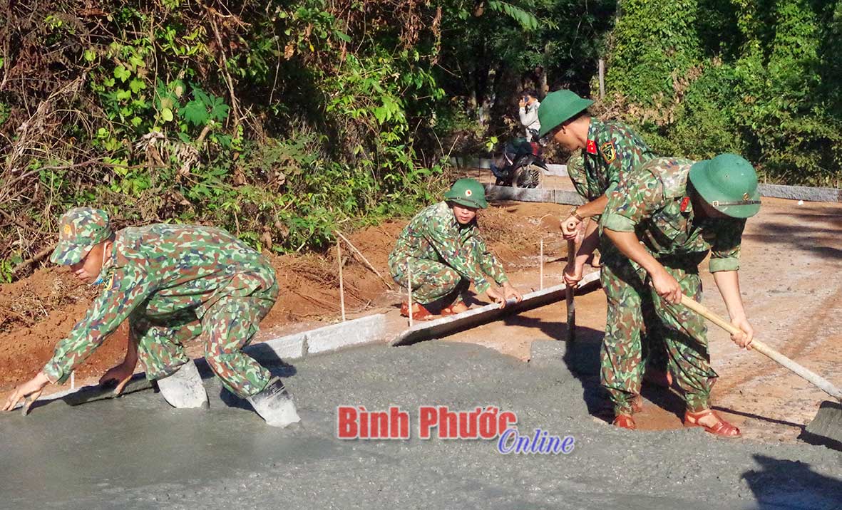 Lực lượng vũ trang huyện Lộc Ninh tham gia xây dựng đường giao thông nông thôn trên địa bàn huyện - Ảnh: V.L