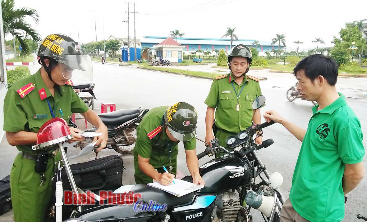 Cán bộ Đồn công an Khu công nghiệp Minh Hưng lập biên bản xử lý người vi phạm Luật Giao thông đường bộ tại KCN Minh Hưng - Hàn Quốc