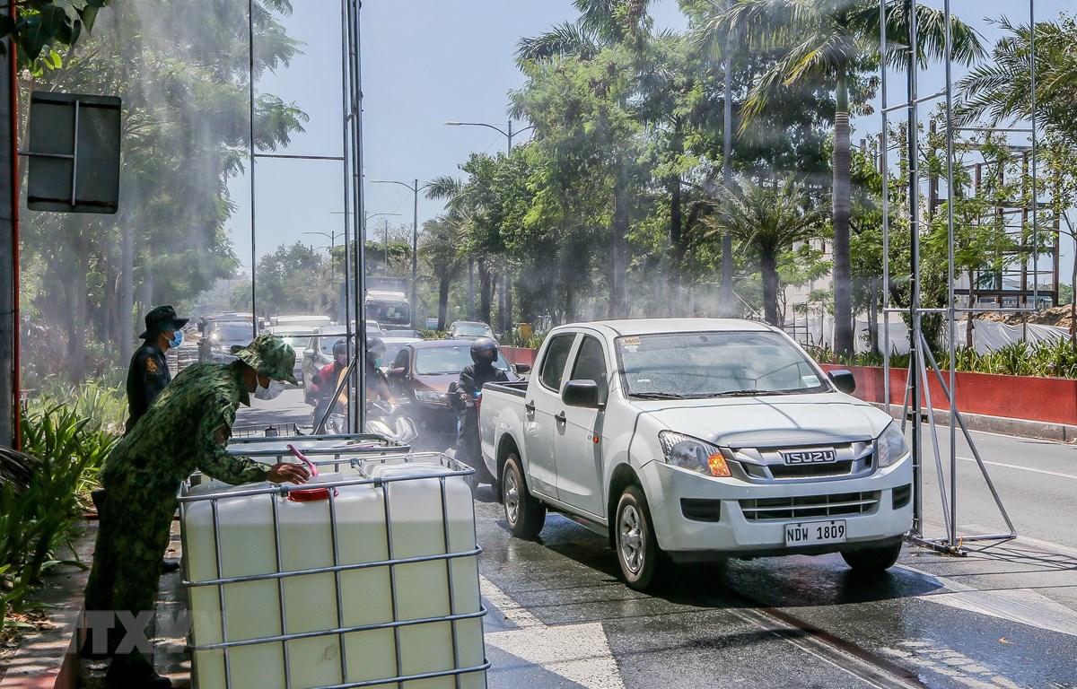 Các phương tiện được phun khử khuẩn trước khi di chuyển vào thủ đô Manila, Philippines ngày 23/3/2020. (Ảnh: THX/TTXVN)