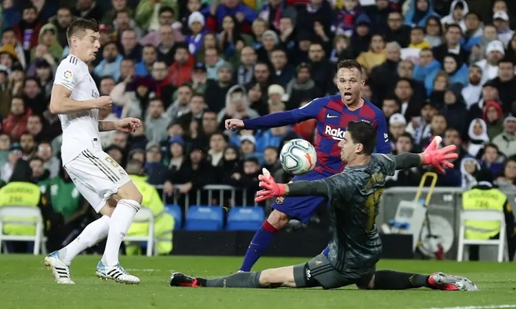 Courtois cứu thua cho Real trong pha đối mặt với Arthur. Ảnh: PA.