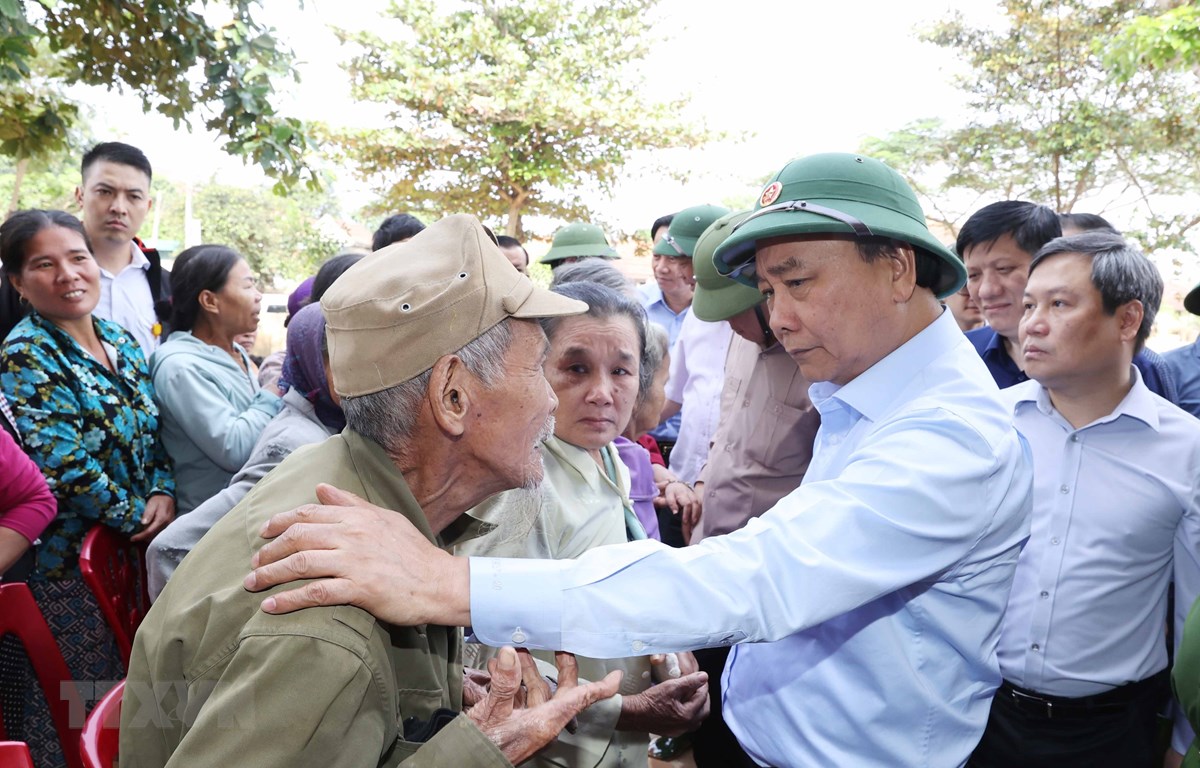 Thủ tướng Nguyễn Xuân Phúc thăm hỏi, chia sẻ khó khăn, mất mát với nhân dân thôn Đồng Tư, xã Hiền Ninh, huyện Quảng Ninh, tỉnh Quảng Bình. (Ảnh: Thống Nhất/TTXVN)